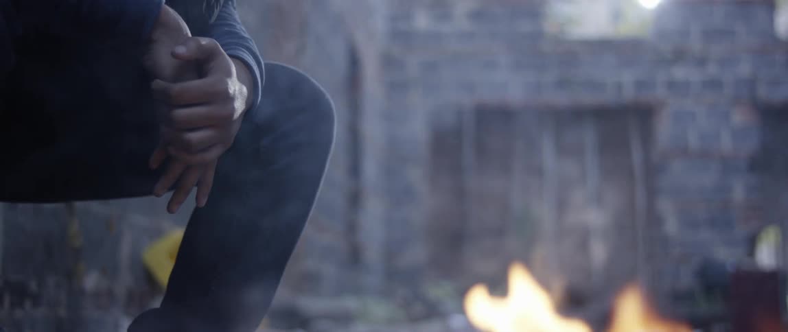 Woman sitting next to burning trash