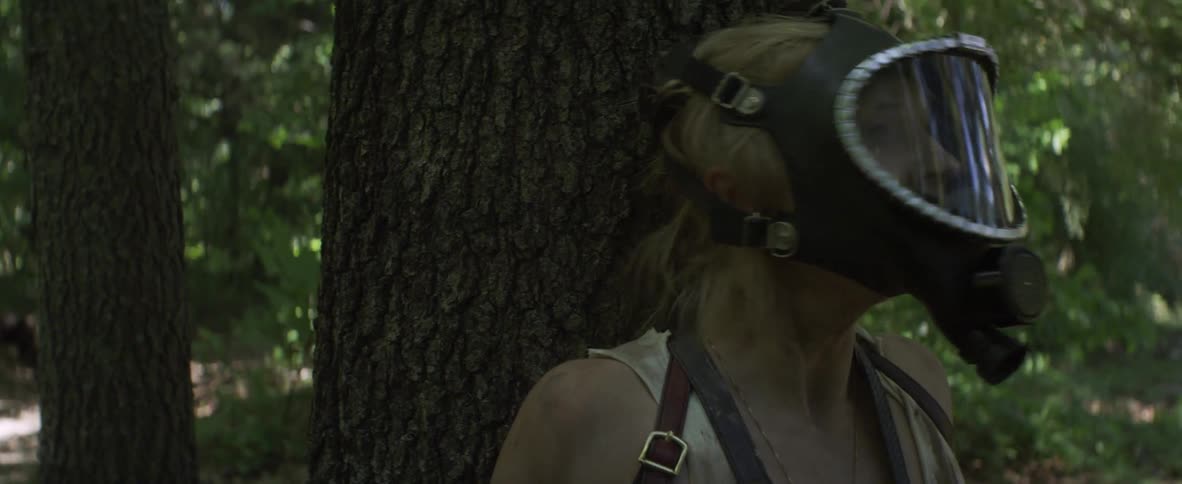 A person is crouched down as another hides behind a tree