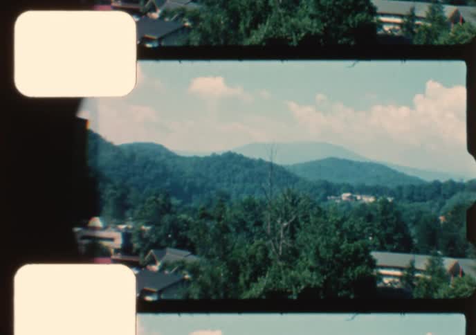 A vintage 1960s film captures aerial views of a small mountain town and the American Museum of Atomic Energy