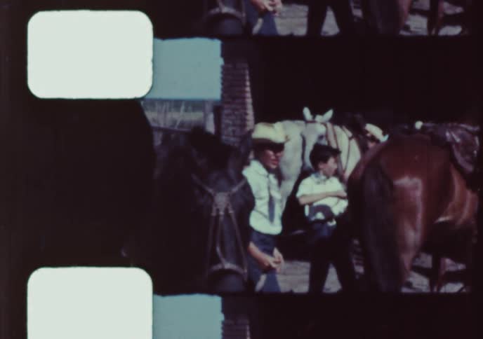 Vintage footage shows young boys and men preparing their horses for a ride at a ranch