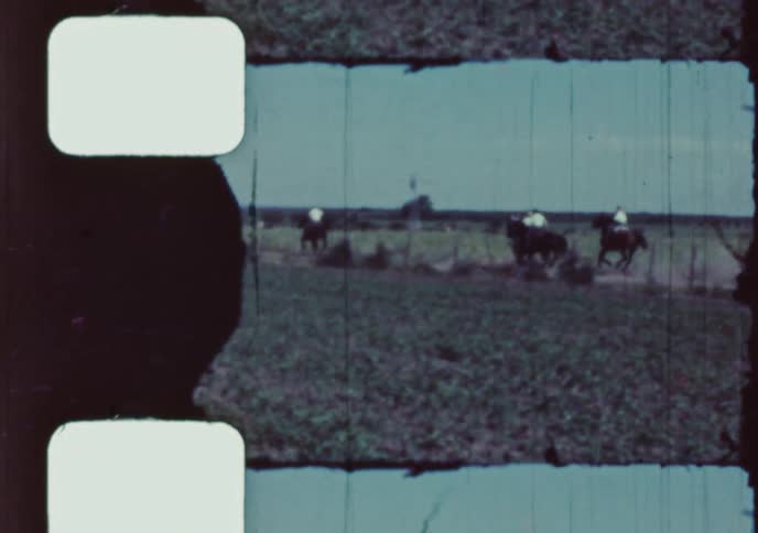 Vintage footage shows a group of young men and boys on horseback riding and racing through the countryside