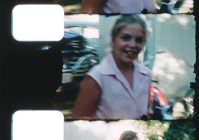 A compilation of vintage 8mm film clips showing a family taking pictures with retro cameras in their backyard