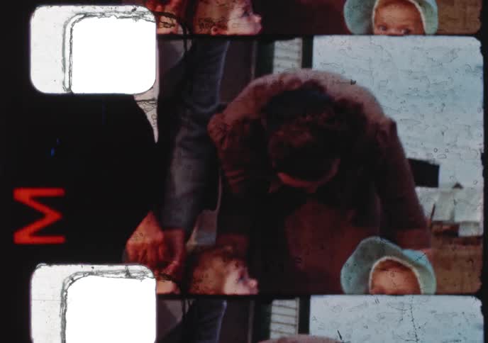 Archival footage from the 1960s shows two cute babies, one drinking milk from a bottle and the other making funny faces