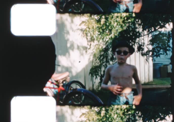Vintage 8mm film scan shows a boy in a fedora posing with two women, then acting cool in sunglasses in a backyard