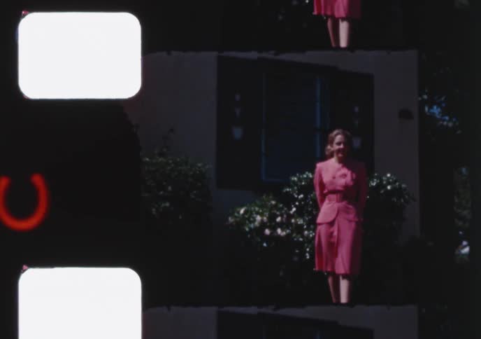 Vintage film strip footage shows a boy on a swing set and a woman in a stylish pink suit from the 1940s