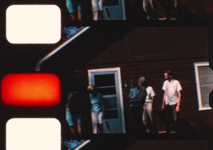 Authentic vintage footage shows a multi-generational family with a baby enjoying a sunny day gathering outside a wooden house