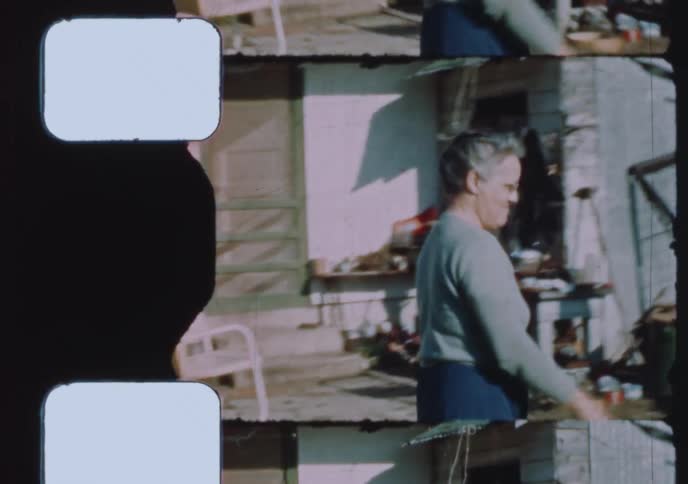 Proud grandparents pose with their newborn grandchild in the backyard in a charming home movie from the 1950s