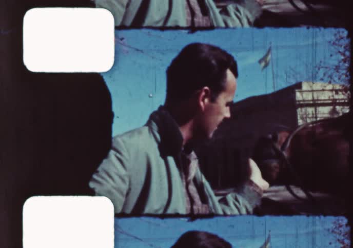 Archival 8mm film captures a man with a mustache petting a horse on a sunny day in the 1960s