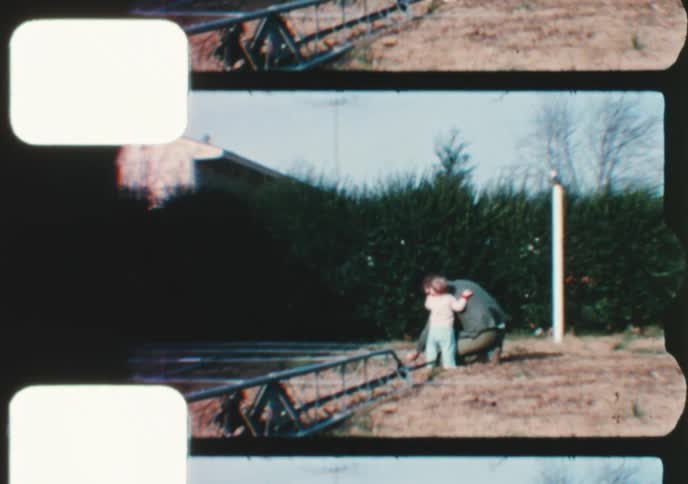 Vintage 16mm film strip captures a happy toddler playing in the yard and 'helping' their father build a radio tower
