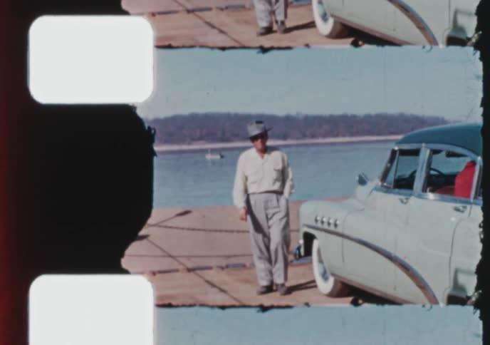 A nostalgic 1950s home movie shows a young boy and girl getting out of a vintage car and posing with their father on a ferry
