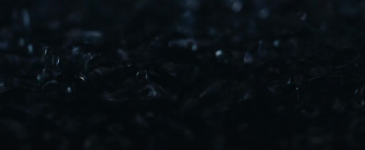 Hypnotic super slow motion macro view of a dark liquid surface vibrating and creating intricate ripples