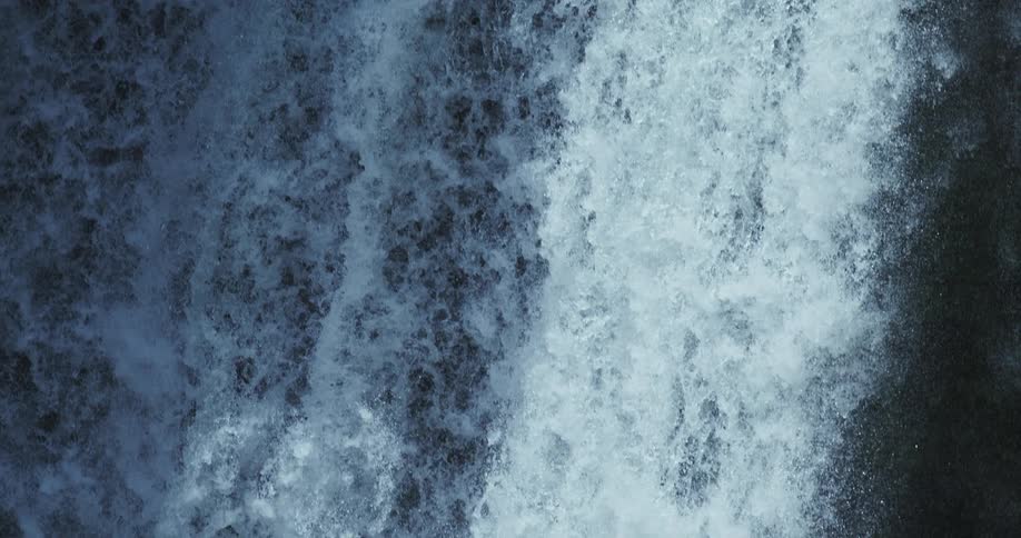 An abstract, super slow-motion close-up of a powerful waterfall creating a wall of white water