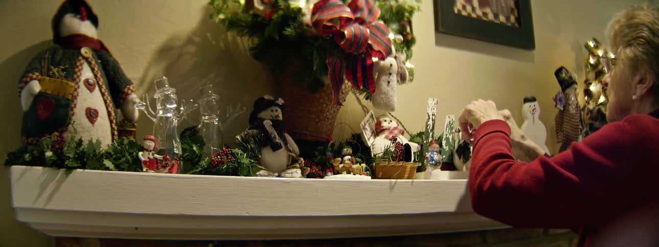 Woman setting up a holiday display on her mantle