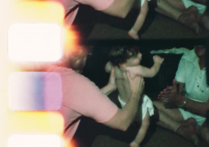 A baby's first steps are captured on vintage 8mm film as its mother and grandmother offer support