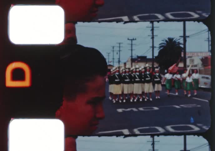 Vintage 8mm film captures a community parade with a marching band, children in costumes, and a religious procession