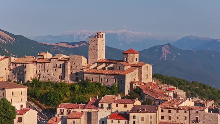 A timeless, static view of the historic Italian mountain village of Castel del Monte in the Abruzzo region, with the Apennine mountains in the background