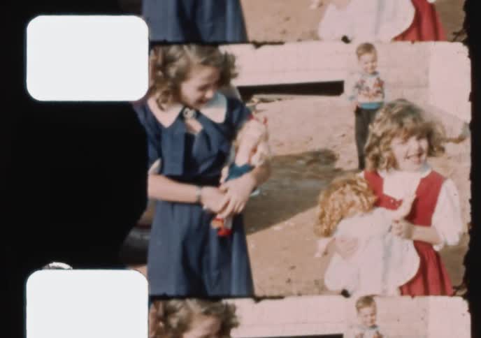 Vintage 16mm film captures scenes of happy children playing with their dolls in the backyard during the 1940s