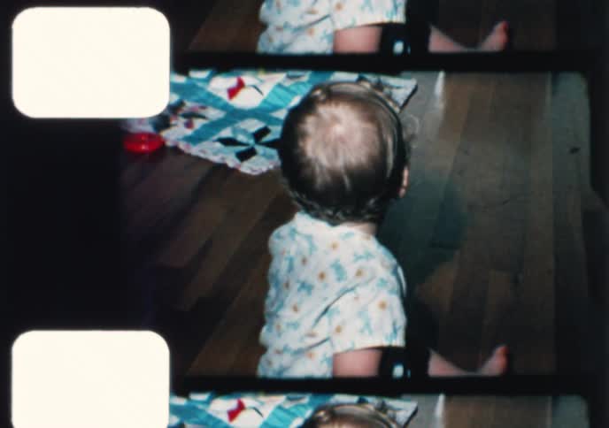 Archival 8mm film shows a happy baby boy crawling, standing, and smiling for the camera in the 1960s