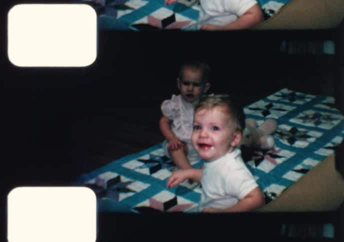 Vintage 1960s footage of two adorable toddlers playing together on a colorful quilt