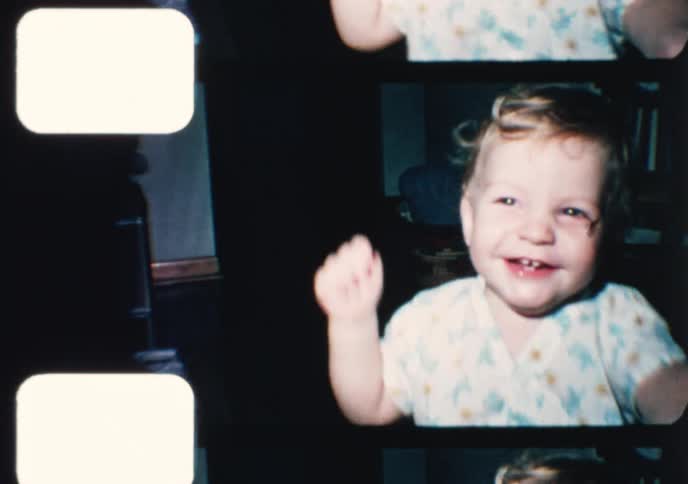 A happy toddler dances and smiles for the camera in a charming vintage home movie from the 1970s
