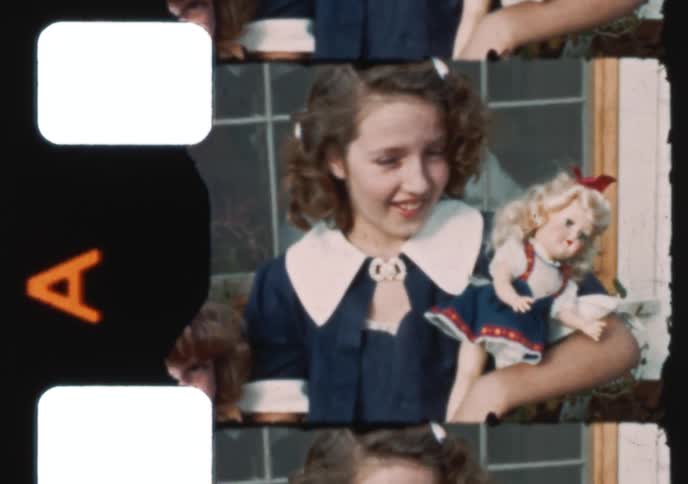 A group of children and their dog pose for the camera outside of their home in a charming 1950s home movie