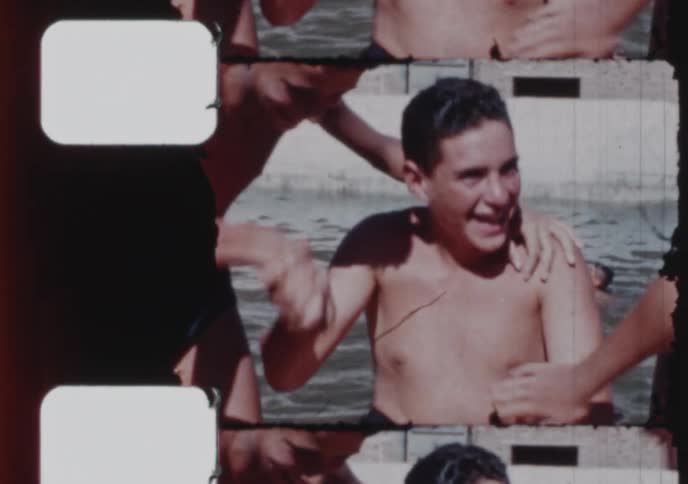 Archival footage captures a group of smiling teenagers playfully interacting and having fun in a swimming pool on a sunny summer day