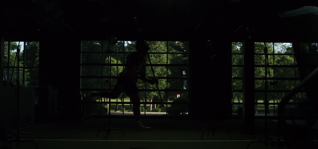 Dramatic slow-motion video of a female lacrosse player jumping and running, with strobe lights flashing to reveal her powerful athletic form