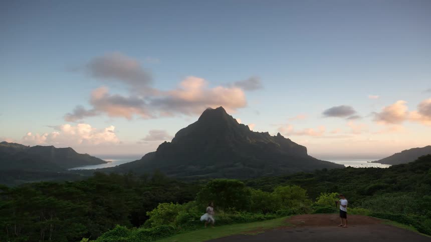 A spectacular sunrise timelapse shows clouds clearing from a majestic tropical mountain overlooking two beautiful bays