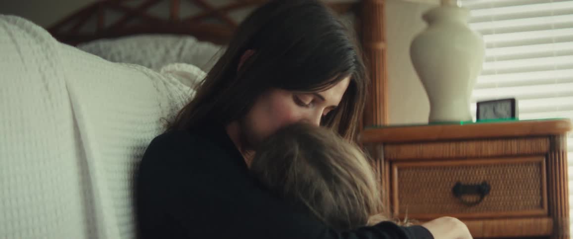 A mother and daughter share an intimate moment as the little girl embraces her mom in a comforting hug