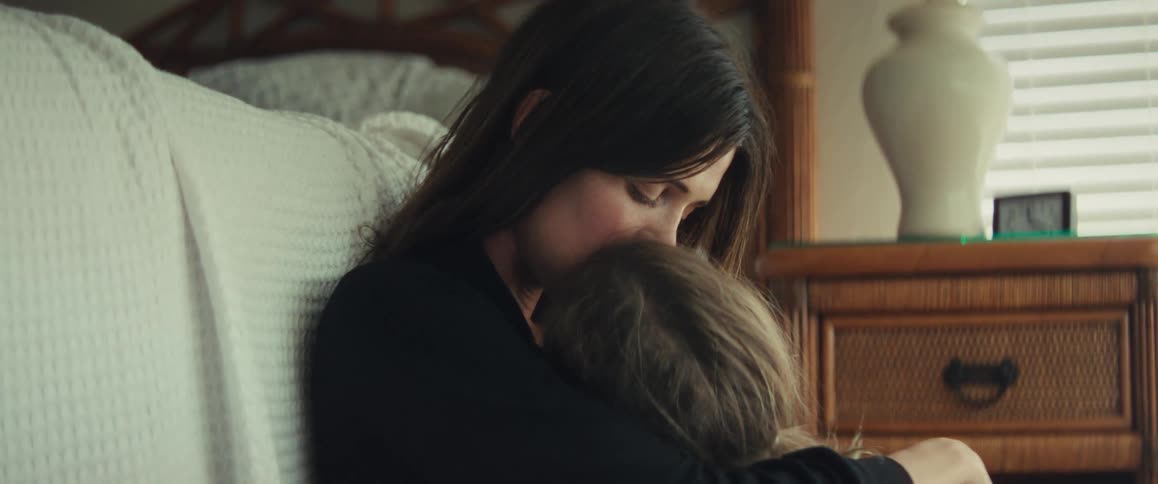 A mother and daughter share an intimate moment as the little girl embraces her mom in a comforting hug