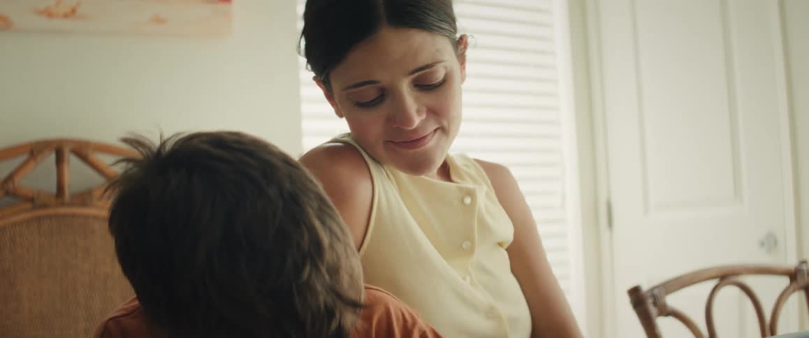 A loving mother smiles tenderly at her young son during a quiet moment at home