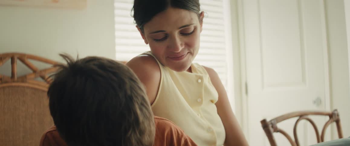 A loving mother smiles tenderly at her young son during a quiet moment at home