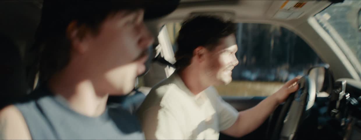 A man runs to a waiting SUV and joins his friend for an exciting road trip through the woods, laughing and talking on their adventure