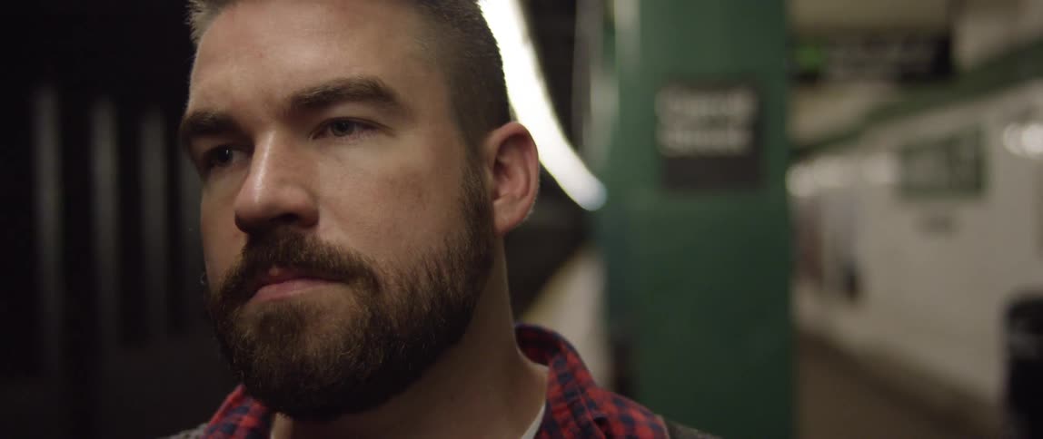 Close up of a man standing on a subway station platform