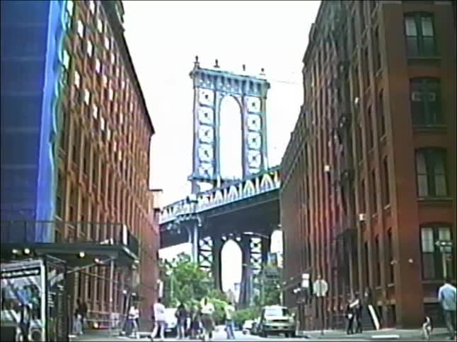 Vintage VHS footage captures the iconic view of the Manhattan Bridge from a bustling street in DUMBO, Brooklyn
