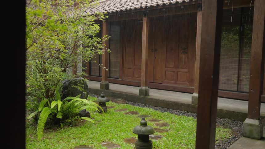 A peaceful rain shower nourishes the lush garden in the courtyard of a traditional Asian-style home
