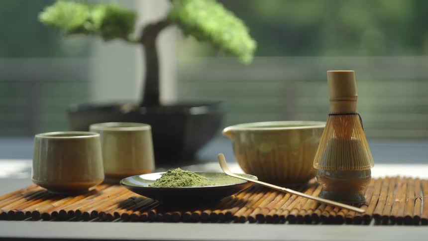 A serene still life of a traditional matcha green tea set with a bonsai tree, ready for a Japanese tea ceremony
