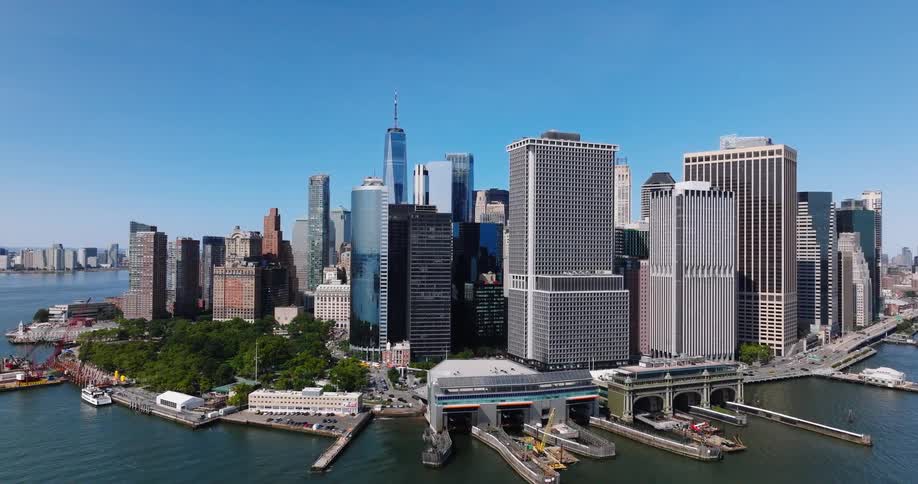 Aerial view flying toward the iconic Lower Manhattan skyline and Financial District in New York City on a bright sunny day