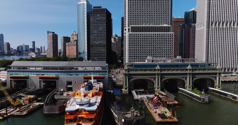 Aerial view pulls back from the Staten Island Ferry at the Whitehall Terminal in Lower Manhattan on a sunny day