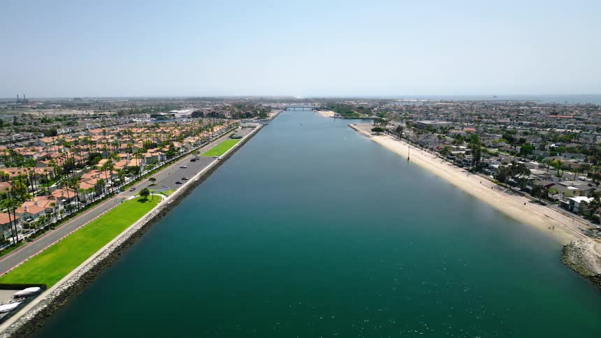 Aerial view over the Long Beach Marine Stadium with coastal homes and blue skies