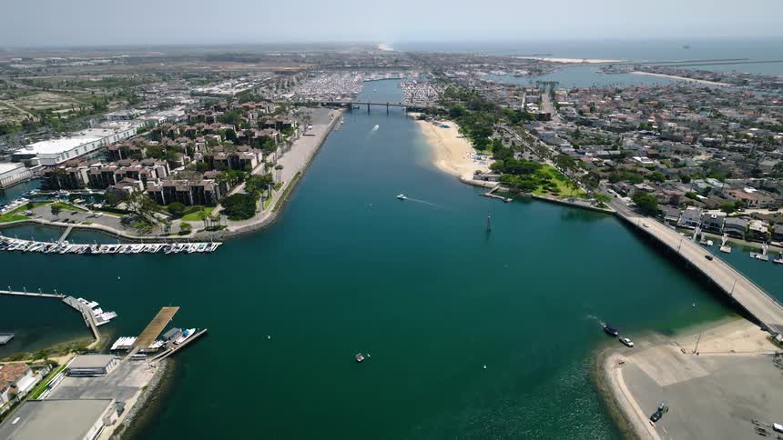 An expansive aerial shot captures the beautiful Channel Islands Harbor with its many boats, bridges, and residences on a clear day