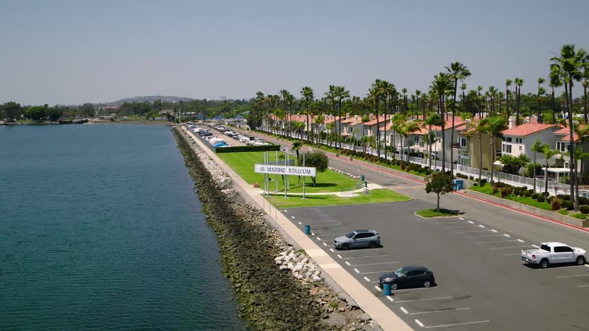Slow aerial drone footage approaches the iconic Marine Stadium sign in Long Beach, California, on a beautiful sunny day