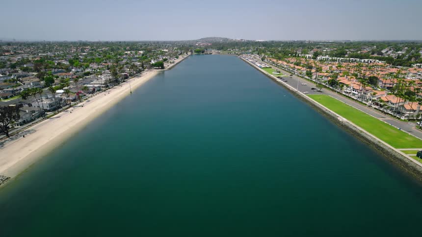 A wide aerial view of the serene Long Beach Marine Stadium on a bright, sunny day