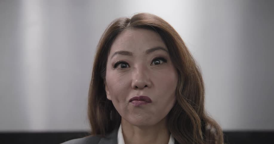 Close up of a professional Asian woman with an annoyed and disapproving facial expression