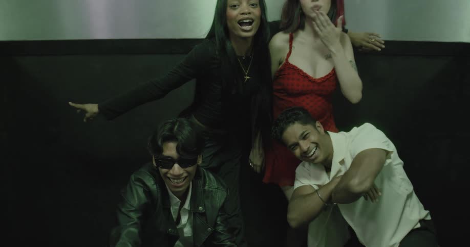 A stylish group of diverse friends energetically pose and make funny faces inside an elevator as the doors close