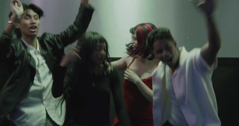A group of stylish friends dances enthusiastically in an elevator as the doors open and close, capturing a moment of youthful energy