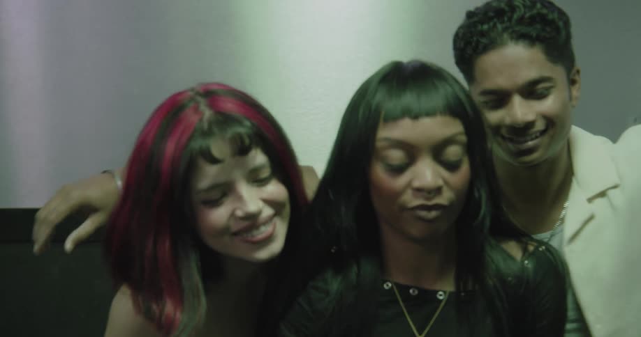 Excited friends pile into a photo booth, dancing and posing for a memorable selfie at a party