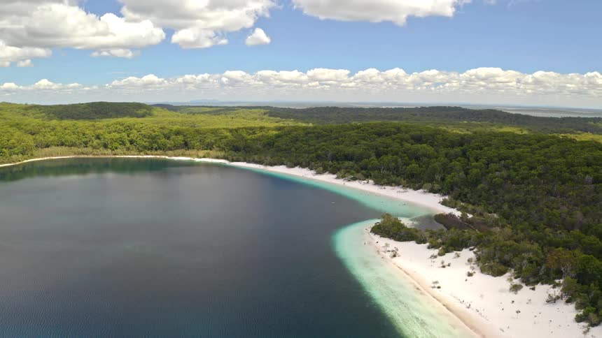 Breathtaking static aerial view of the stunning Lake McKenzie on Fraser Island, showcasing its crystal-clear turquoise waters and pure white sand beach surrounded by lush forest