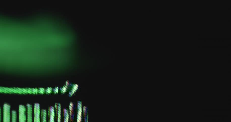 Close-up of a digital green financial bar graph on a computer screen showing a positive upward trend and growth