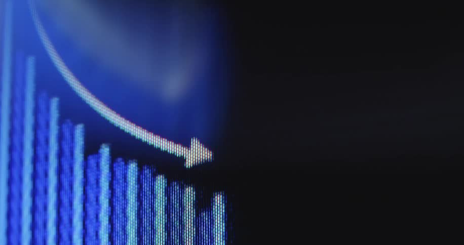 Close-up macro of a financial bar graph on a digital screen with a white arrow pointing down, indicating a downward trend, recession, or stock market crash